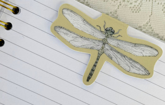 Notebook with a dragonfly bookmark on a lace background